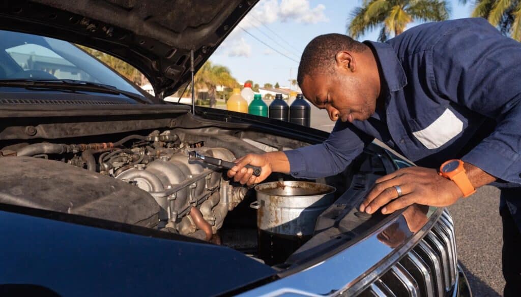 Mechanic performing an oil change in sunny Florida, emphasizing engine maintenance importance